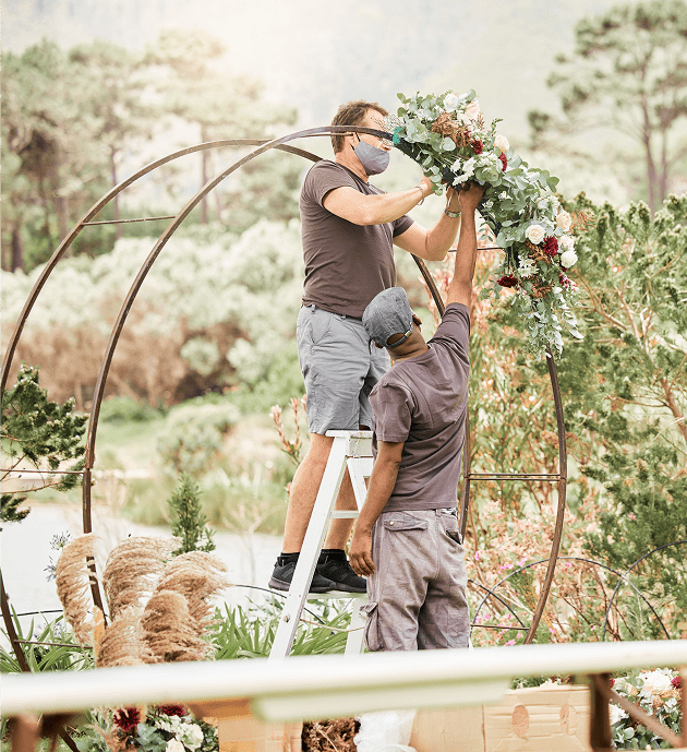Two men arranging floral display