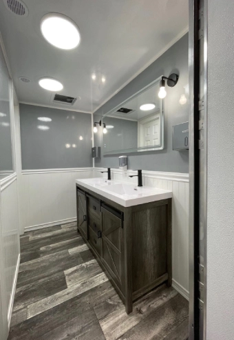 Modern bathroom with double sinks and large mirror.