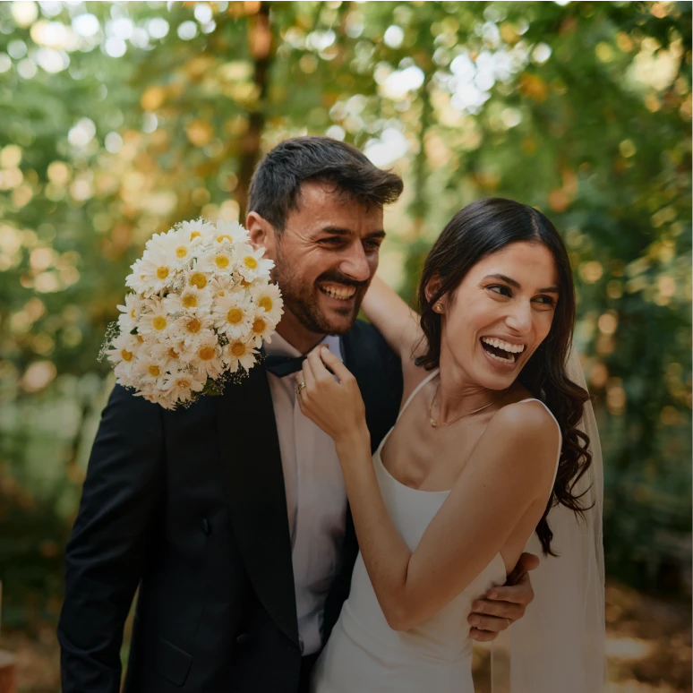 Newlyweds smiling with bouquet